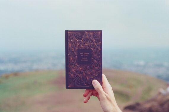 person holding book selective focus photography