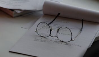 black framed eyeglasses on top of white printing paper