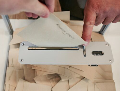 person holding white machine on top of white table